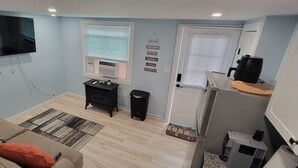 Una sala de estar con televisión de pantalla plana, un sofá, una mesa de centro y un mueble negro.