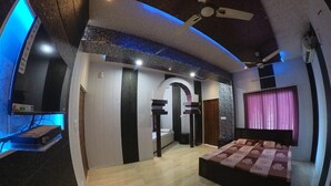 Una camera da letto moderna con un letto, una ventola a soffitto e un televisore montato a parete.