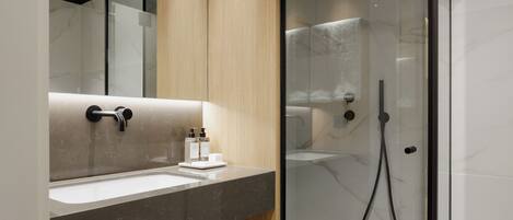 Un baño moderno con lavamanos de mármol, paneles de madera y cabina de ducha con paredes de vidrio.