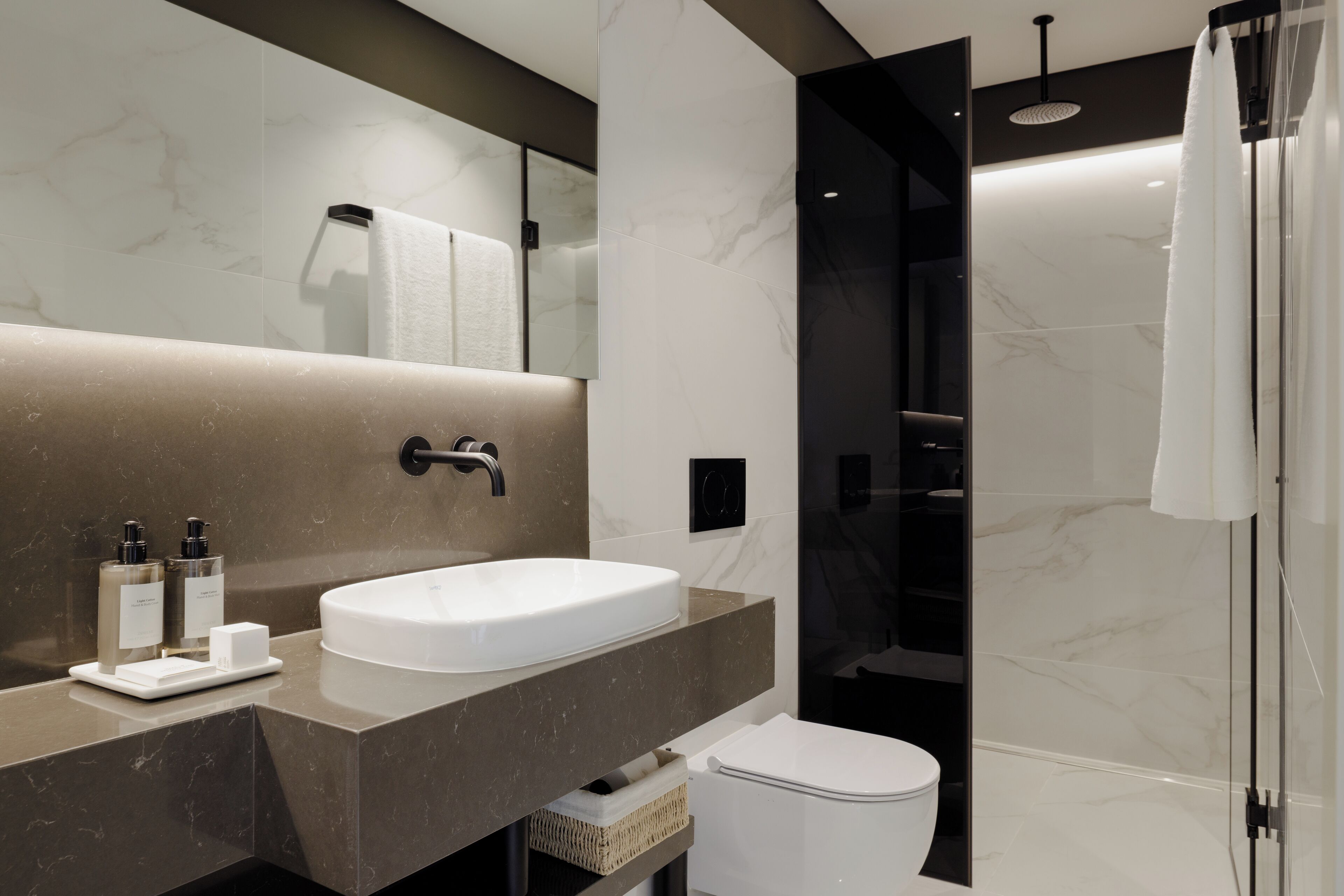 Une salle de bain moderne avec un grand lavabo, un miroir et une douche.