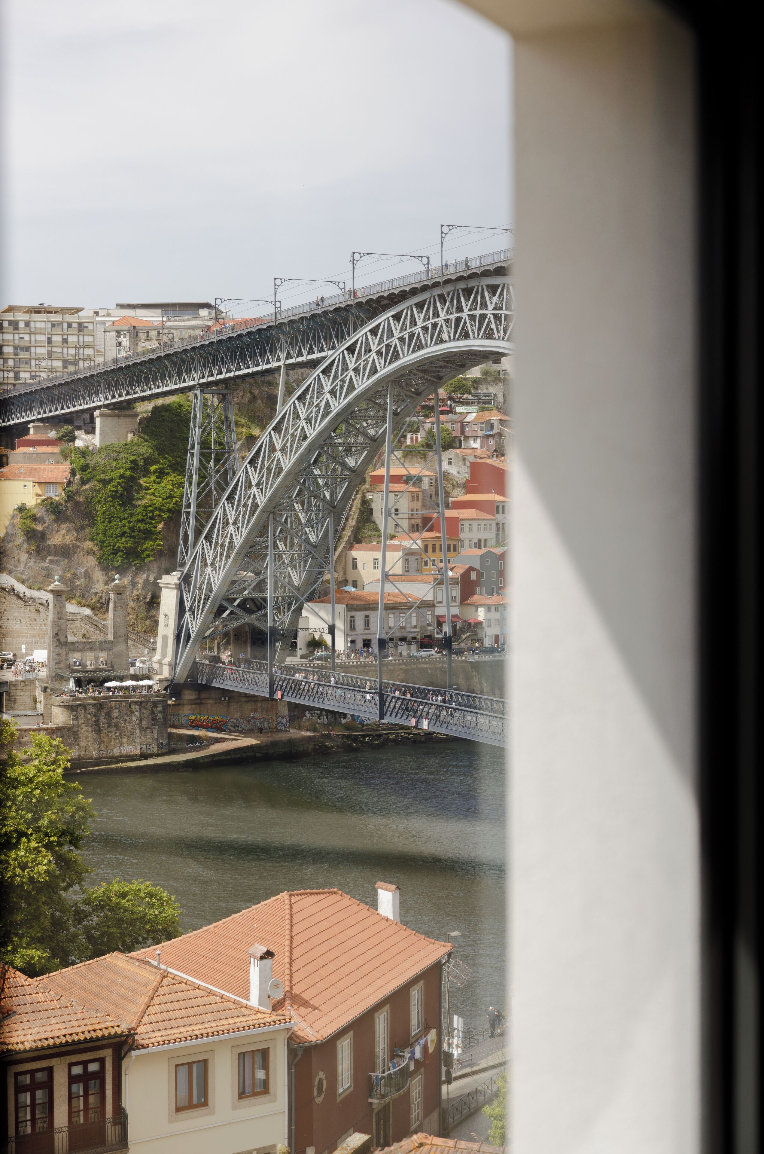 A view of a bridge over a river with buildings in the background.