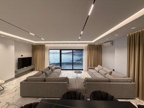 Penthouse Deluxe, vista al mar | Área de sala de estar | Televisión 
