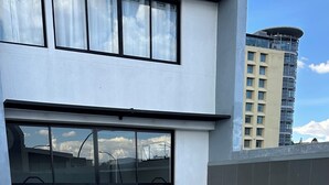 Una piscina con escalones de cerámica y vistas a un edificio moderno con amplios ventanales.