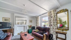 A living room with a television, leather sofa, and a fireplace. - 4/5 Bed-2 Bath-bar-pool Table-library-parking For7 (Dorchester)