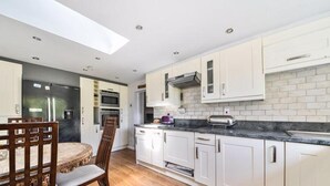 A modern kitchen with white cabinets, a black countertop, and a built-in oven. - 4/5 Bed-2 Bath-bar-pool Table-library-parking For7 (Dorchester)