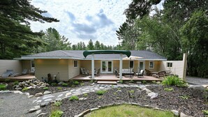 A two-story house with a covered patio, a stone pathway, and a landscaped garden. - Newly renovated large space - great for groups (Hayward)