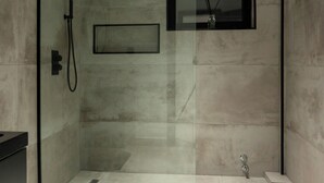 A modern bathroom with a glass-enclosed shower, a toilet, and a sink. - The VVS Apartments - Two-Bedroom Apartment with Pool View (Accra)