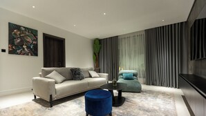 A modern living room with a sofa, ottoman, and a coffee table.