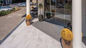 The exterior of Quinta Baleira with a clear view of the entrance, outdoor seating area, and surrounding urban environment. - Vila Baleira Residence (Funchal)