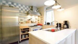 A modern kitchen with a stainless steel refrigerator, a gas stove, and a sink. - Holiday Home in Bouillon Near River Semois (Bouillon)