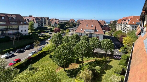 Zona residencial con varios edificios de apartamentos, un estacionamiento y áreas verdes.