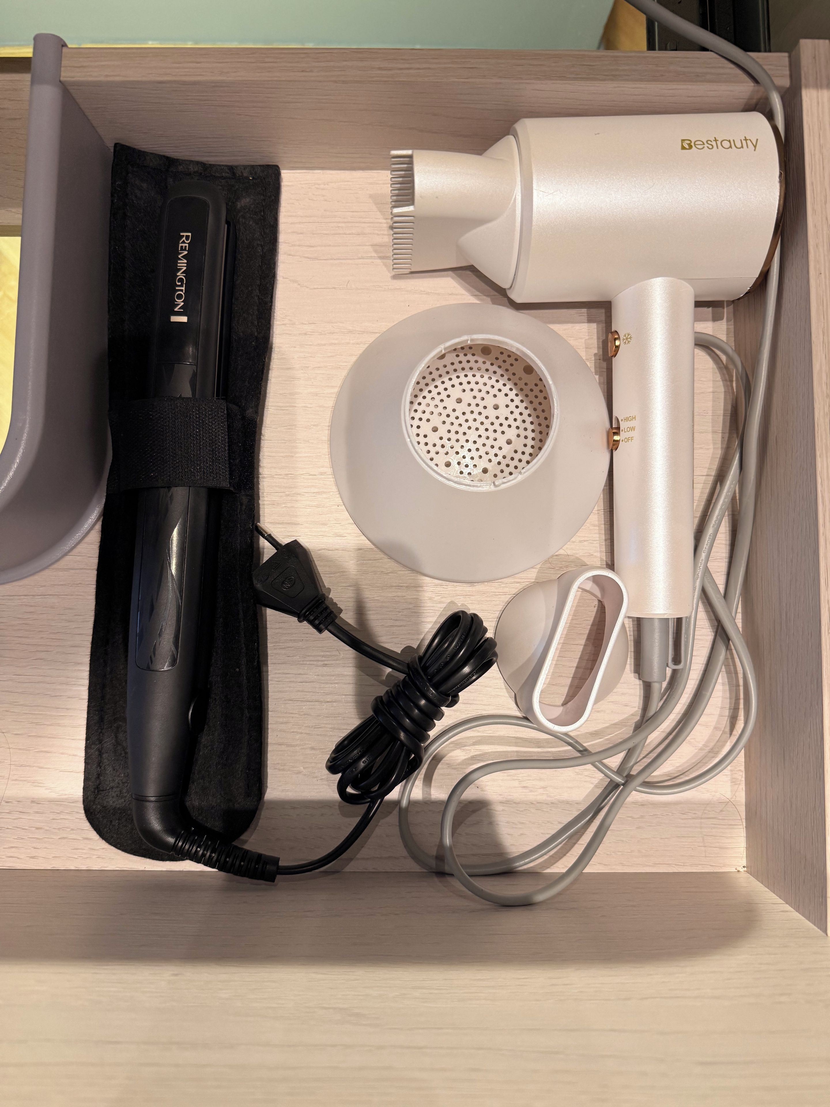 A hair styling device with its accessories neatly arranged in a drawer.