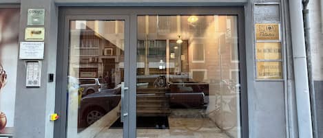 A building entrance with a glass door, a sign for 'ENJOY Pilates,' and a 'STUDIO LEGALE' sign.