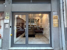 A building entrance with a glass door, a sign for 'ENJOY Pilates,' and a 'STUDIO LEGALE' sign.