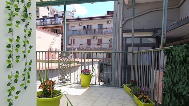 A balcony with potted plants and a metal railing. - The Rose of Pompeii (Scafati)