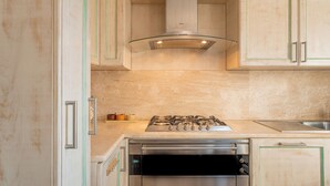 A kitchen with a gas stove, dishwasher, and a stainless steel range hood.