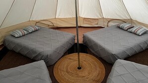 A tent with four beds, each with a pillow and a blanket. - Large Group Glamping Tent Sleeps 8Yokahu Bell Tent, near Concerts, Casino, Falls (Harris)