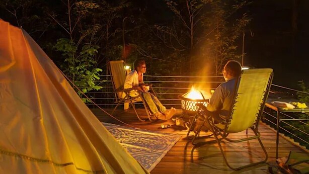 A tent, two chairs, and a campfire on a wooden deck. - Riverfront Bell Tent Glamping -15 minutes to Bethel Woods Concerts (Harris)