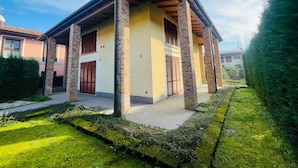 A modern house with a covered porch, brick columns, and a well-maintained garden. - CR BnB Rozzano (Rozzano)