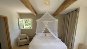 A bedroom with a bed under a canopy, a window, a sofa, and a patterned rug. - Mas Joseph amid vineyards and olive groves, 7 minutes from downtown Aix-en-Provence (Venelles)