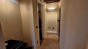 A narrow hallway with a tiled floor, a black printer, and a door leading to another room. - Il Corridore - Piccolo Borgo Tralacoasta (Berceto)