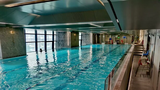 An indoor swimming pool with clear water, a tiled floor, and a glass barrier. - New CBD high-rise 3-brm LOFT, Huaxun Center, Luohu (Shenzhen)