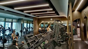 A modern gym with various exercise equipment, large windows, and a mirror wall. - New CBD high-rise 3-brm LOFT, Huaxun Center, Luohu (Shenzhen)