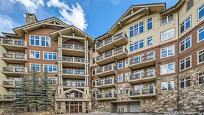 A multi-story hotel with balconies, stone facade, and a central entrance. - Luxurious Ski-In/Ski-Out Condominium in the Heart of Mountain Paradise (Keystone)