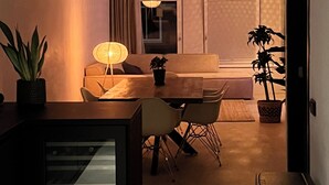 Un espace de vie compact comprenant un coin repas, un canapé, une table et un téléviseur.