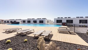 A pool area with lounge chairs and a lifebuoy. - Modern apartment near the sea in Tenerife. (Abades)