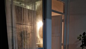 A bedroom with a bed, a window with curtains, a door, and a potted plant. - 4-bedroom hotel in peaceful Krung Thep Maha Nakhon with AC, WiFi (Krung Thep Maha Nakhon)