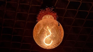 A spherical light fixture with a glowing spiral design, hanging from a dark pole against a brick wall background. - 4-bedroom hotel in peaceful Krung Thep Maha Nakhon with AC, WiFi (Krung Thep Maha Nakhon)