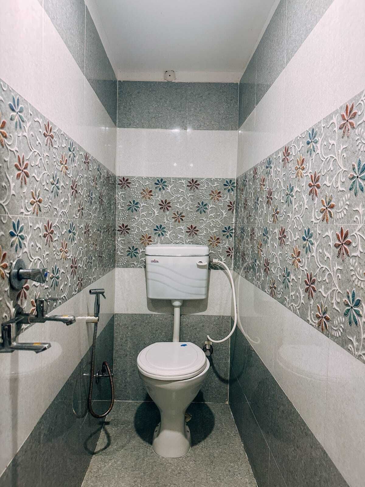 A bathroom with a toilet, shower, and sink.