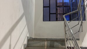 A staircase with metal railings and a window with multiple panes.
