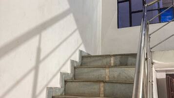 A staircase with a metal handrail leading to a landing.