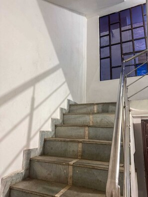 A staircase with a metal handrail leading to a landing.