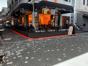 A restaurant with outdoor seating, a menu board, and a sign reading 'Sweet Pine.' - Çam otel (Altinoluk)