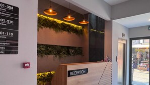 A reception desk with a sign indicating reception, rooms, restaurant, and lobby.