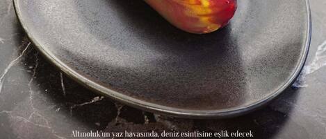A plate with a sweet pineapple on a dark surface.