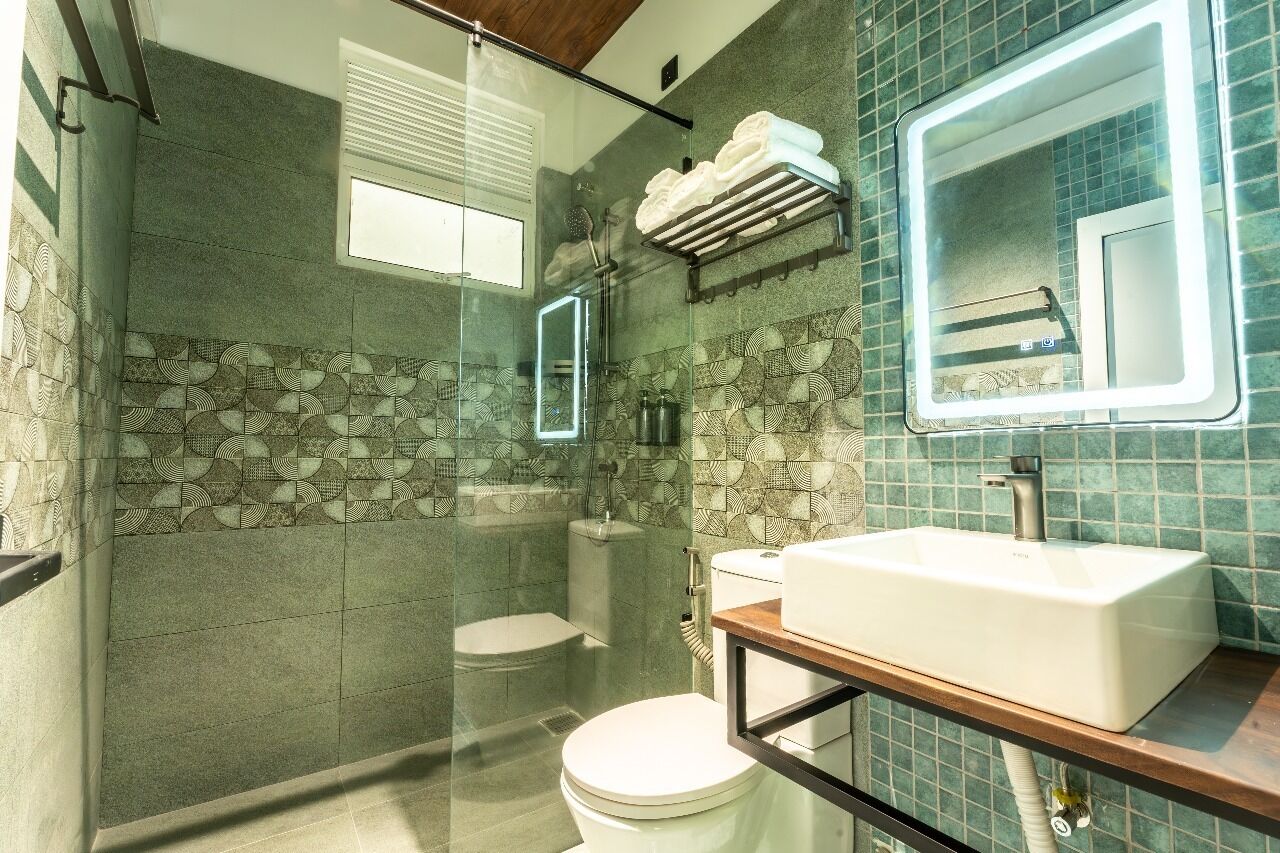 A modern bathroom with a glass-enclosed shower, a white sink, and a toilet.