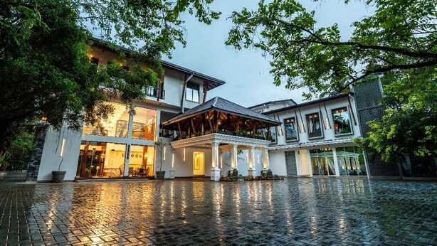 A modern building with a spacious courtyard, large windows, and a covered outdoor seating area. - Grand Minaro  (Welipillawa)