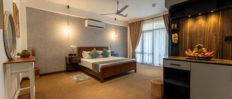 A bedroom with a bed, bedside tables, a ceiling fan, an air conditioning unit, a wooden cabinet, and a decorative fruit basket.