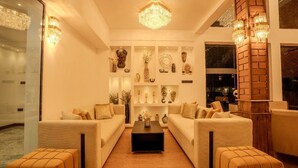 A modern living room with two sofas, a coffee table, and decorative items on shelves. - Grand Minaro  (Welipillawa)