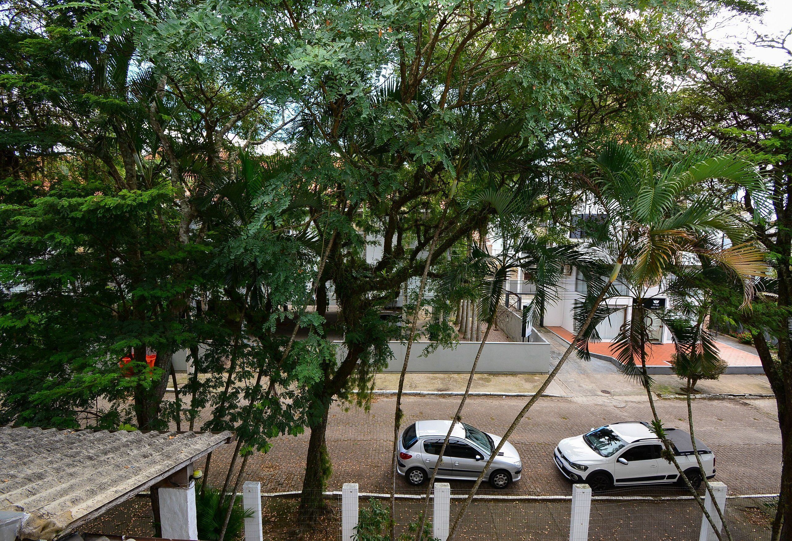 A street view with two parked cars and a building in the background.