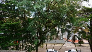 Une vue de rue avec deux voitures garées et un bâtiment en arrière-plan.