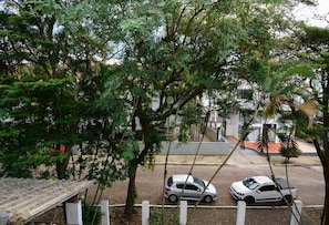 Straßenansicht mit zwei geparkten Autos und einem Gebäude im Hintergrund.