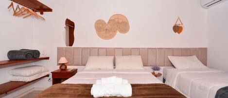 A hotel room with a wooden ceiling, a bed with a brown headboard, two bedside tables with lamps, and a wall decoration.