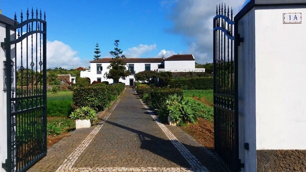 A pathway leading to a white building with a number plaque '1A'.