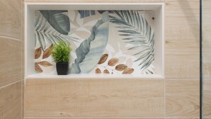 A bathroom with a wooden wall and a shelf containing a potted plant and a decorative item. - Domus Mameli Apartment C (Cagliari)