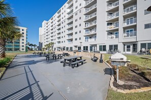 Un moderno edificio de apartamentos con balcones, mobiliario exterior y un patio bien cuidado.